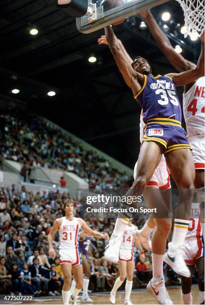 Darrell Griffith of the Utah Jazz goes up for a layup on Cliff Robinson of the New Jersey Nets during an NBA basketball game circa 1980 at the...
