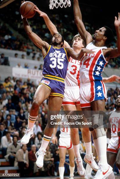 Darrell Griffith of the Utah Jazz goes up for a layup on Cliff Robinson of the New Jersey Nets during an NBA basketball game circa 1980 at the...