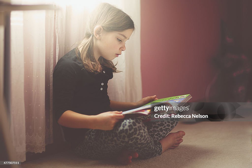 Girl reading in her bedroom