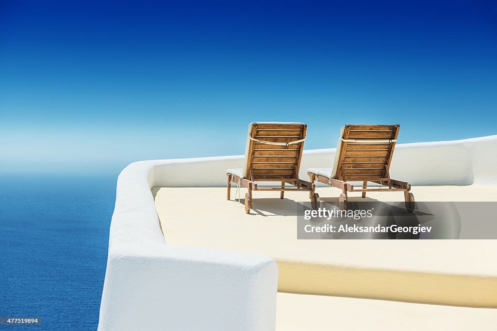 Empty Sun Lounge Chair on balcony In Santorini at Sunrise