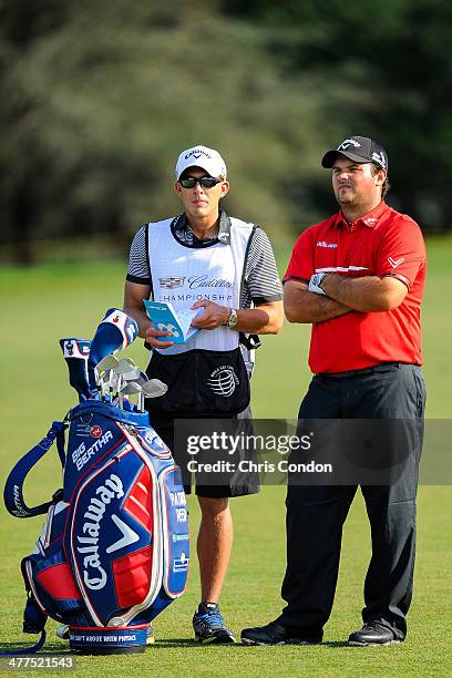 Patrick Reed speaks with his caddie Kessler Karin while playing on the 12th hole during the final round of the World Golf Championships-Cadillac...