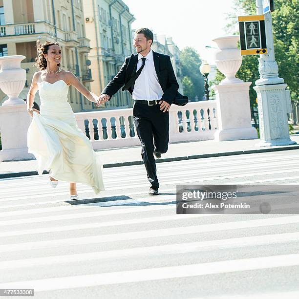 real wedding: bride and groom run across the street - bride running stock pictures, royalty-free photos & images