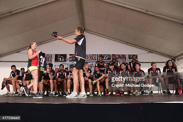 Rhys Stanley gives a hat to a fan when receiving his jumper during a St Kilda Saints AFL Fan Day at Frankston Foreshore on March 10, 2014 in...