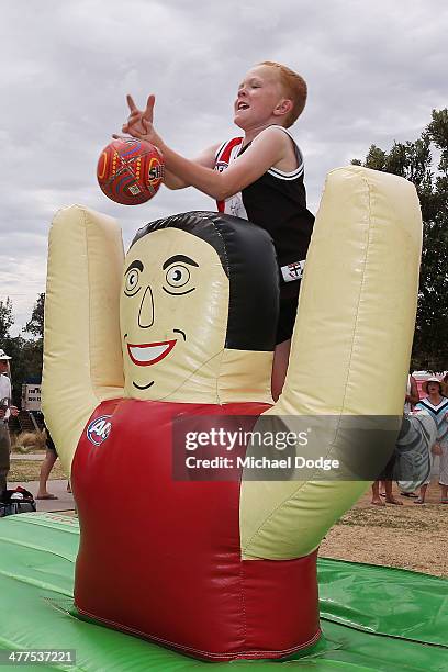 Saints fan marks a ball during a St Kilda Saints AFL Fan Day at Frankston Foreshore on March 10, 2014 in Melbourne, Australia.