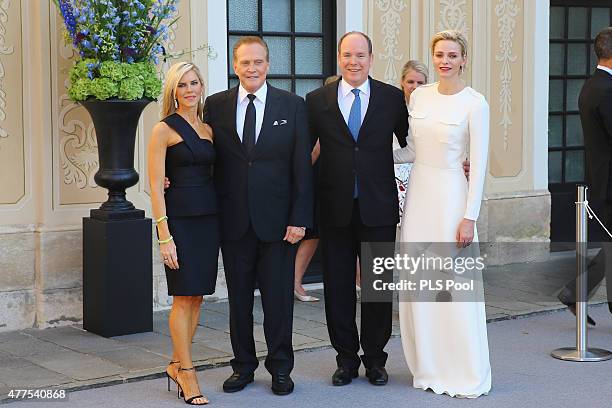 Prince Albert II of Monaco and Princess Charlene of Monaco pose with actor Lee Majors and wife during the Monaco Palace cocktail party of the 55th...