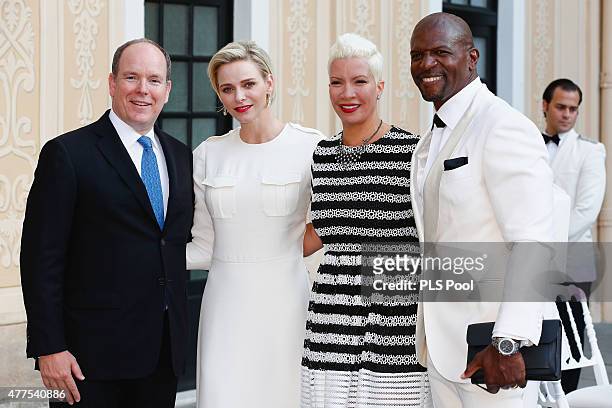 Prince Albert II of Monaco and Princess Charlene of Monaco pose with actor Terry Crews and wife during the Monaco Palace cocktail party of the 55th...