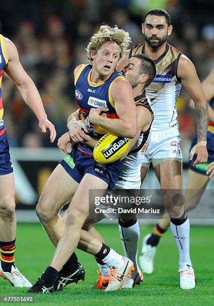 Rory Sloane of the Crows is tackled by Matt Suckling of the Hawks during the round 12 AFL match between the Adelaide Crows and the Hawthorn Hawks at...