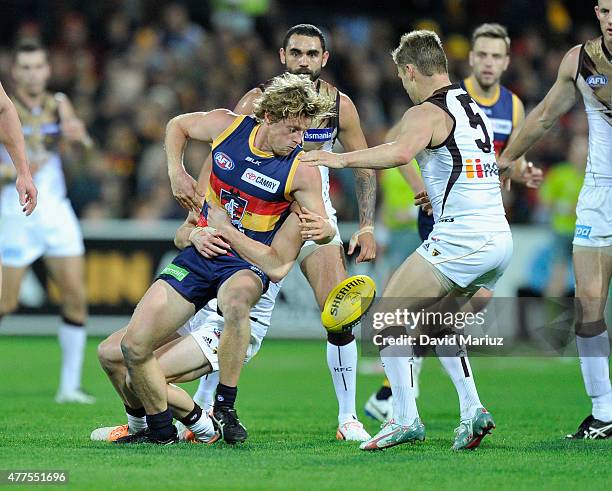 Rory Sloane of the Crows is tackled by Matt Suckling of the Hawks during the round 12 AFL match between the Adelaide Crows and the Hawthorn Hawks at...