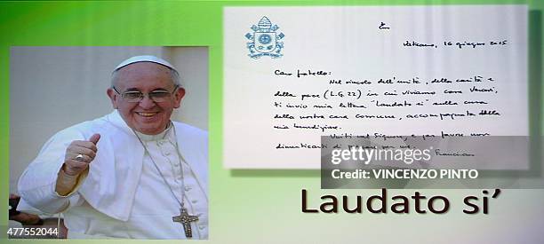 Poster of Pope Francis with his handwritten letter is pictured the day when his encyclical on climate change titled "Laudato Sii", a collection of...