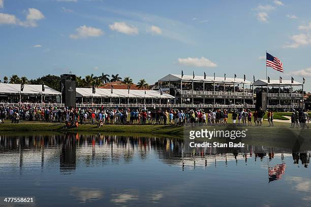 Fans line the ninth green to watch action there and on the 18th green during the final round of the World Golf Championships-Cadillac Championship at...