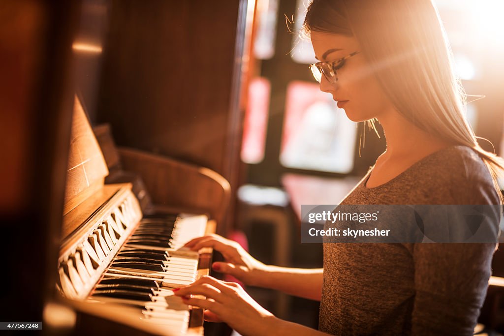 Bela mulher tocando piano antigo.