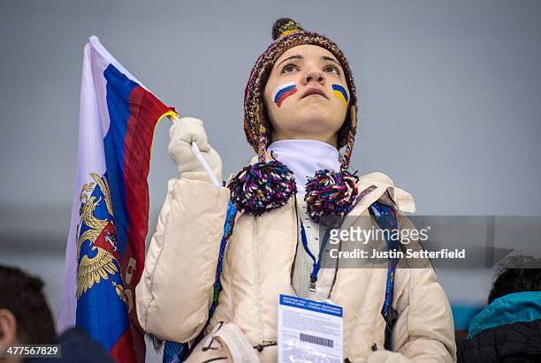 Young fan looks on at the wheelchair curling with a Ukraine flag on one cheek and a Russian flag on the other cheek during the wheelchair curling...