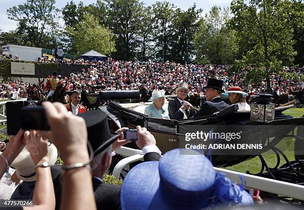 Britain's Queen Elizabeth II and her husband Britain's Prince Philip, Duke of Edinburgh arrive in a horse-drawn carriage at the parade ring during...