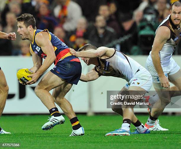 Matthew Wright of the Crows is tackled by Luke Breust of the Hawks during the round 12 AFL match between the Adelaide Crows and the Hawthorn Hawks at...