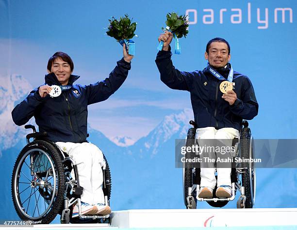 Silver medalist Taiki Morii and gold medalist Akira Kano of Japan celebrate on the podium at the medal ceremony during the Sochi 2014 Paralympic...