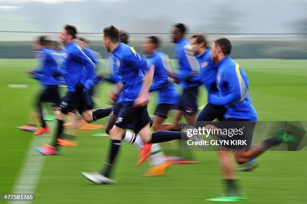 Arsenal players warm up during a training session at Arsenal's training ground at London Colney, north of London, on March 10 one day ahead of their...