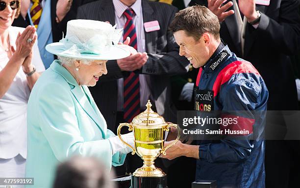 Queen Elizabeth II presents the Gold Cup to wnning jockey Graham Lee as she attends Ladies Day on day 3 of Royal Ascot at Ascot Racecourse on June...