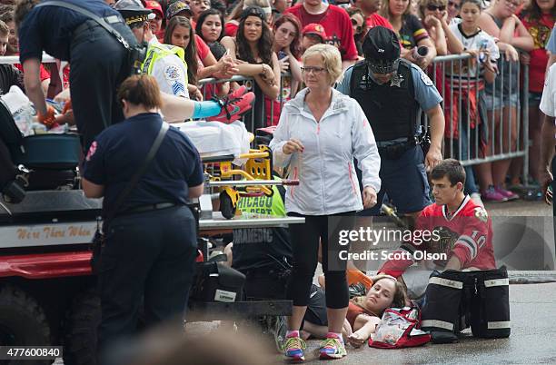 Paramedics treat fans, most of whom were overcome by heat as they waited for the start of a parade to celebrate the Chicago Blackhawks' winning of...