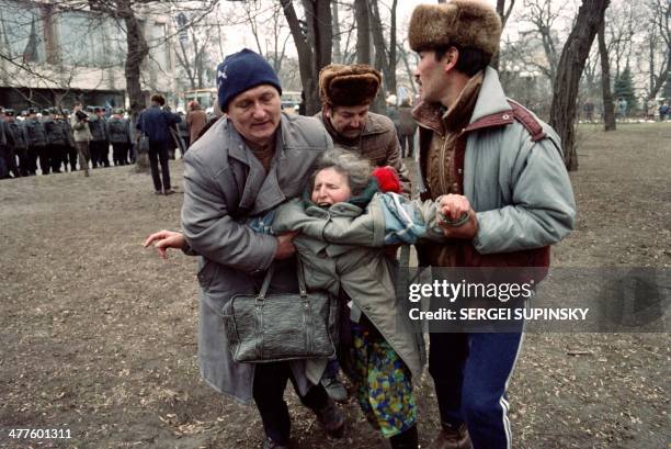 Relatives and friends of a Tatar woman pull her away from a fight around the Ukrainian parliament in Kiev, on March 19 after several hundred Tatars...