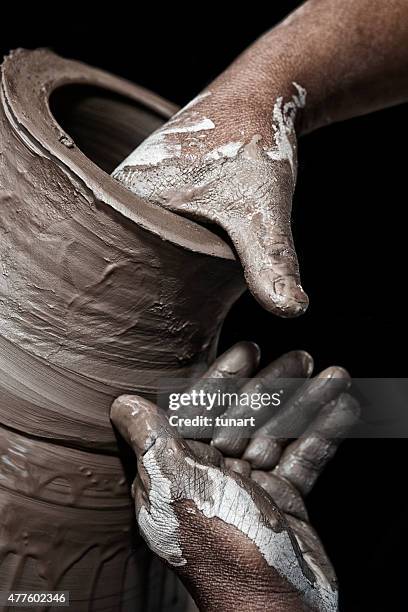 muddy hands of pottery craftsman making terracotta - klei stockfoto's en -beelden