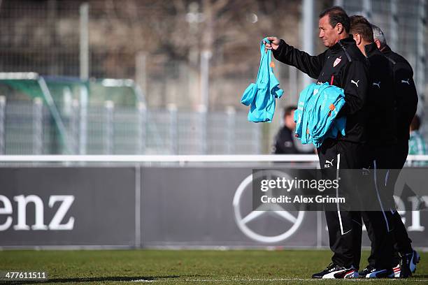 New head coach Huub Stevens of Stuttgart hands out training bibs during a training session at the club's training ground on March 10, 2014 in...