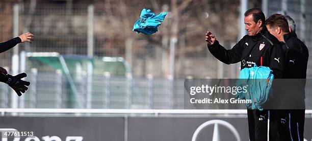 New head coach Huub Stevens of Stuttgart hands out training bibs during a training session at the club's training ground on March 10, 2014 in...