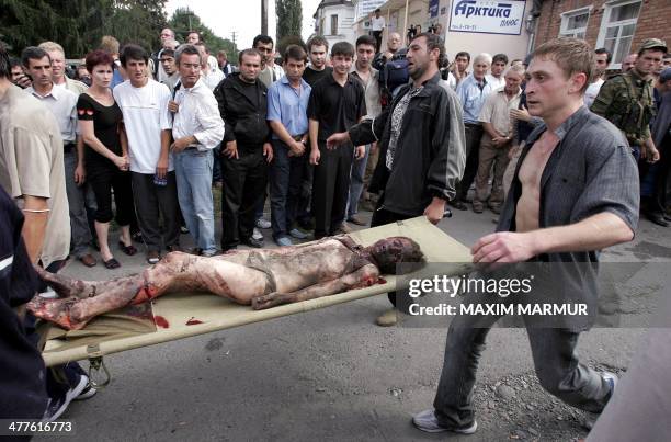 Volunteers carry an injured girl on a stretcher during the rescue operation of Beslan's school, northern Ossetia, 03 September 2004. Dozens of...