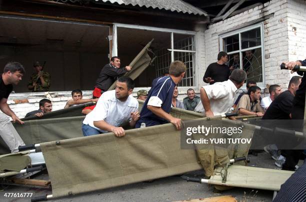 Volunteers hold stretchers during the rescue operation of Beslan's school, northern Ossetia, 03 September 2004. Dozens of corpses of dead hostages...