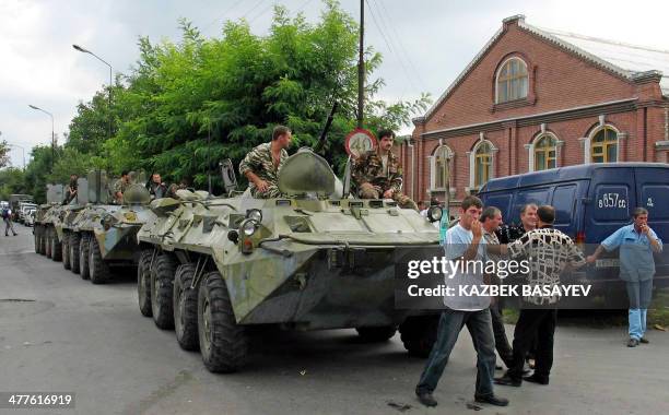 Russian soldiers wait aboard APCs in position near the school, where a group of gunmen, wearing belts laden with explosives, are holding hostage some...
