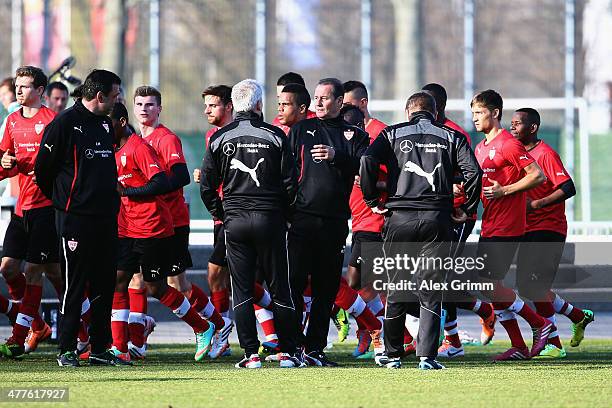 New head coach Huub Stevens of Stuttgart talks to his assistants as players run during a training session at the club's training ground on March 10,...