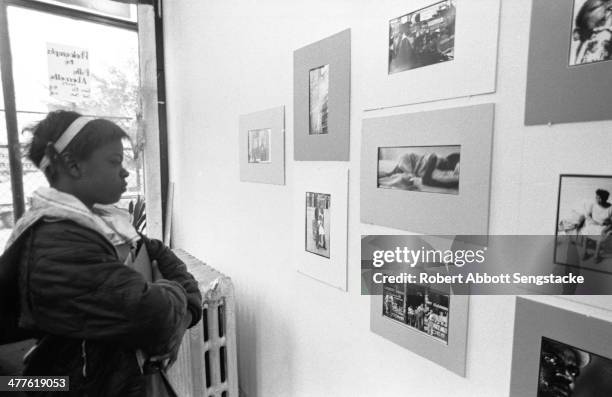 At Shepherd's Studio , a young girl examines photographs by Billy 'Fundi' Abernathy during his 'Live Flicks of the Hip World' exhibition, Chicago,...