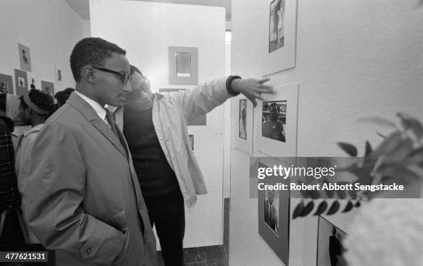 Unidentified people talk at an exhibition of photographer Billy 'Fundi' Abernathy's works at Shepherd's Studio , Chicago, Illinois, 1967.