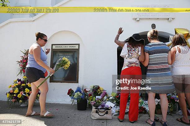 People pray as they pay their respects in front of Emanuel AME Church on June 18, 2015 in Charleston, South Carolina. Nine people were killed on June...