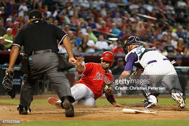 Albert Pujols of the Los Angeles Angels slides in safely to score past the tag from catcher Jarrod Saltalamacchia of the Arizona Diamondbacks during...