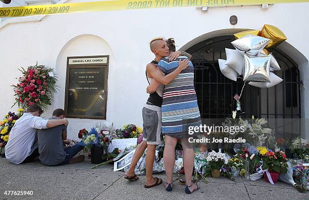 People pay their respects in front of Emanuel African Methodist Episcopal Church after a mass shooting at the church that killed nine people on June...