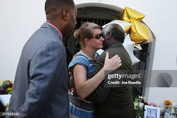 People hug as they pay their respects in front of Emanuel African Methodist Episcopal Church after a mass shooting at the church that killed nine...