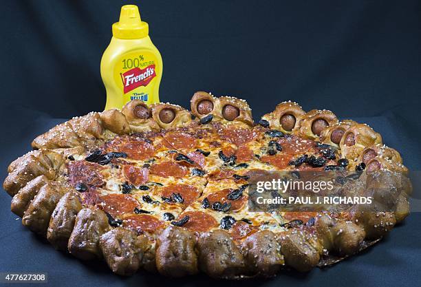 Pizza Hut's Hot Dog Bites Pizza, a new belly busting pizza surrounded by 28 small hot dogs wrapped in a salted pretzel like crust is seen June 18...