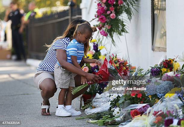 Tamara Holmes and her son, Trenton Holmes lay flowers in front of Emanuel AME Church after a mass shooting at the church that killed nine people of...