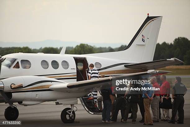 Year-old suspect, Dylann Roof of Lexington, South Carolina, boards a plane at Shelby-Cleveland County Regional Airport for extradition back to...