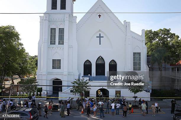 People stand outside the Emanuel AME Church after a mass shooting at the church that killed nine people on June 18 in Charleston, South Carolina. A...