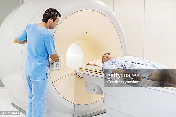 reifer mann erhält ein magnetresonanztomographie. - pet scan machine stock-fotos und bilder