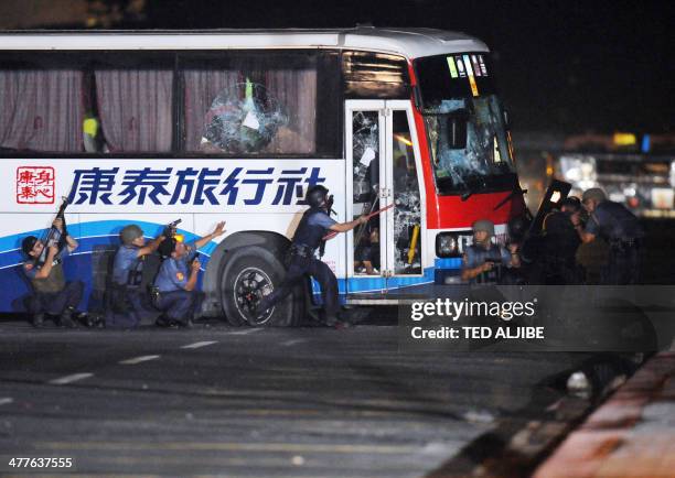 Philippine policemen try to open the door of a tourist bus hijacked in Manila on August 23, 2010. An ex-policeman armed with a high-powered assault...
