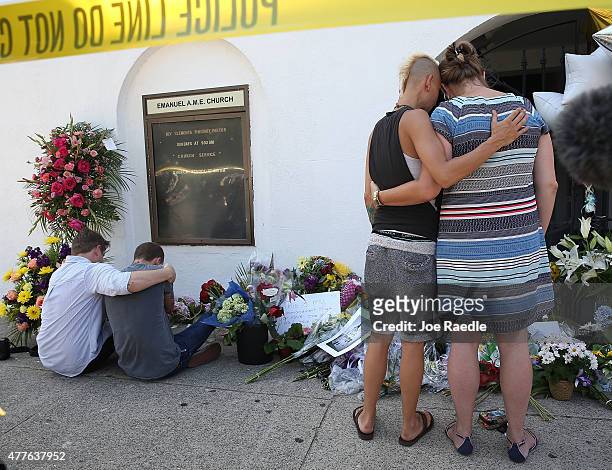People hug as they pay their respects in front of Emanuel African Methodist Episcopal Church after a mass shooting at the church that killed nine...