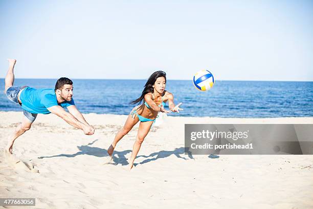 young couple  playing volleyball on the beach - girls beach volleyball stock pictures, royalty-free photos & images