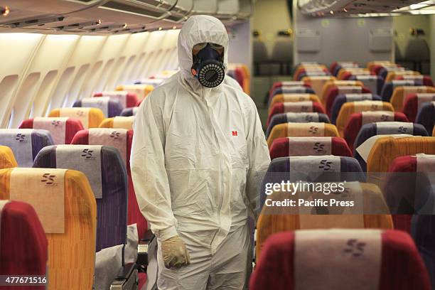 Thai Airways implements preventive measures regarding the MERS virus on THAI flights within affected areas; Thai officers spray disinfectant on...