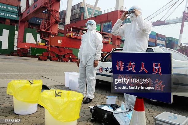 Quarantine officers prepare before boarding ship for inspection during anti-MERS drill at Qingdao Port on June 18, 2015 in Qingdao, Shandong province...