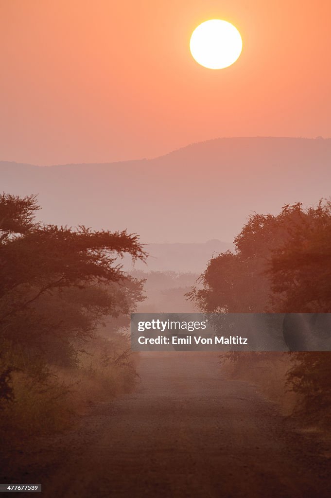 Sunrise at the end of a dirt road in Africa