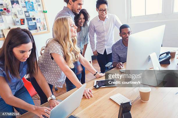 multi ethnic young business team working on computers. - funky office stock pictures, royalty-free photos & images