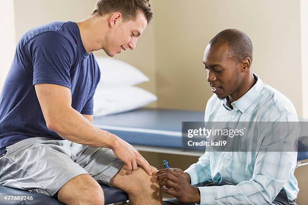 physical therapist examining patient - orthopedist stock pictures, royalty-free photos & images