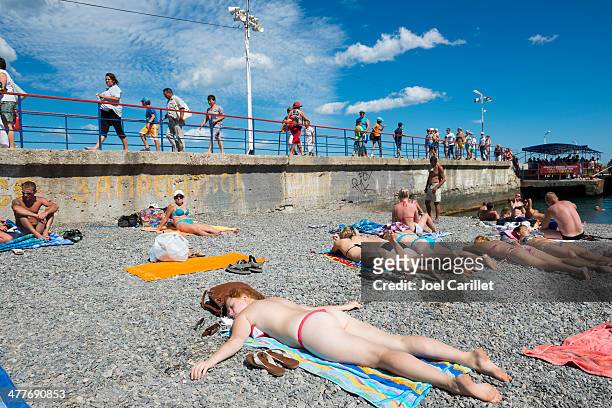 sunbathing on rocky beach in yalta, crimea, ukraine - string stockfoto's en -beelden